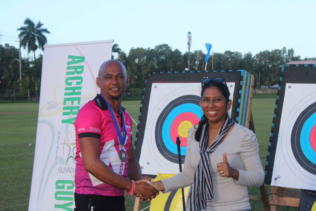 President of Archery Guyana, Ms. Vidushi Persaud-McKinnon on right congratulating Mr. Mehandra Chatargum for securing Gold in Men Barebow